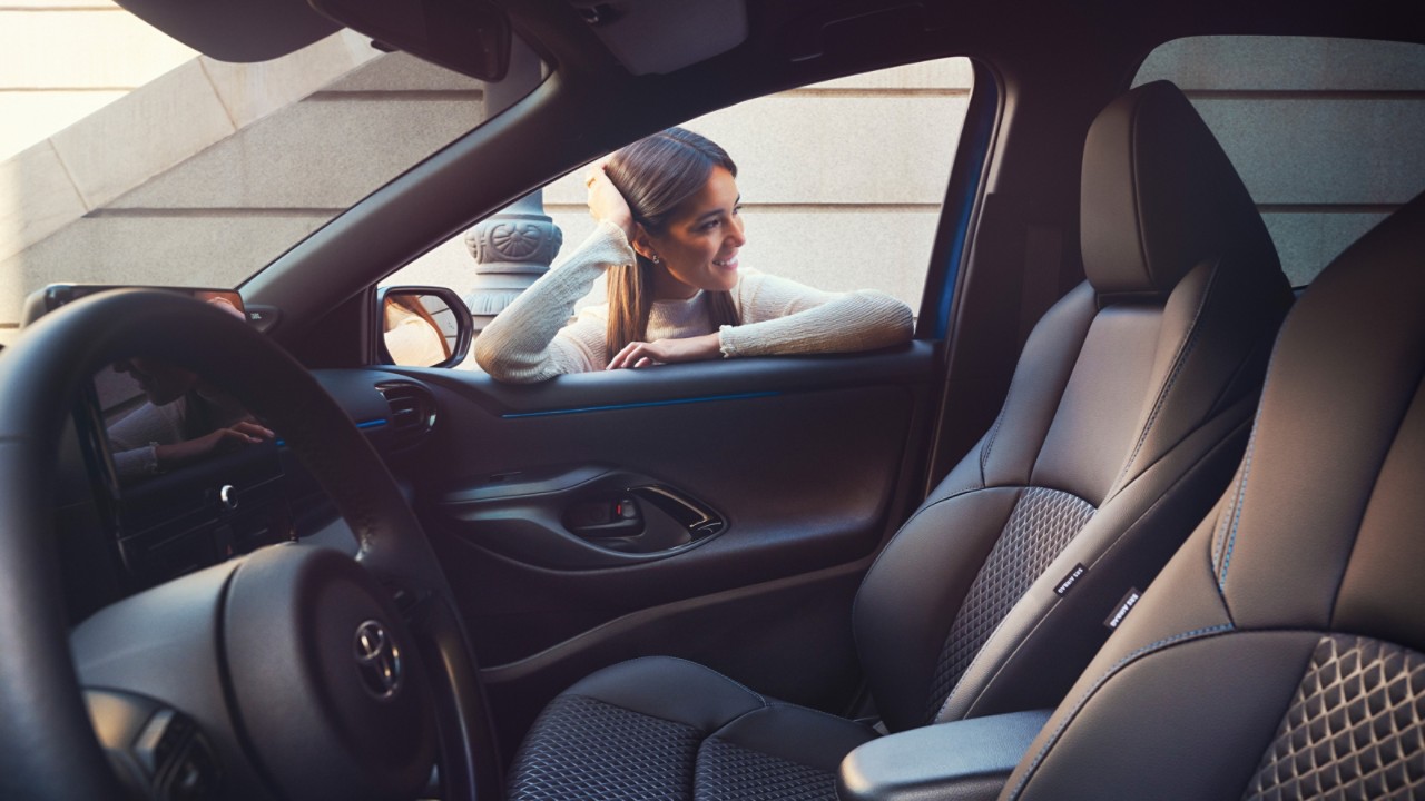 Kadın Toyotasının camından huzurla arabasının içine bakıyor